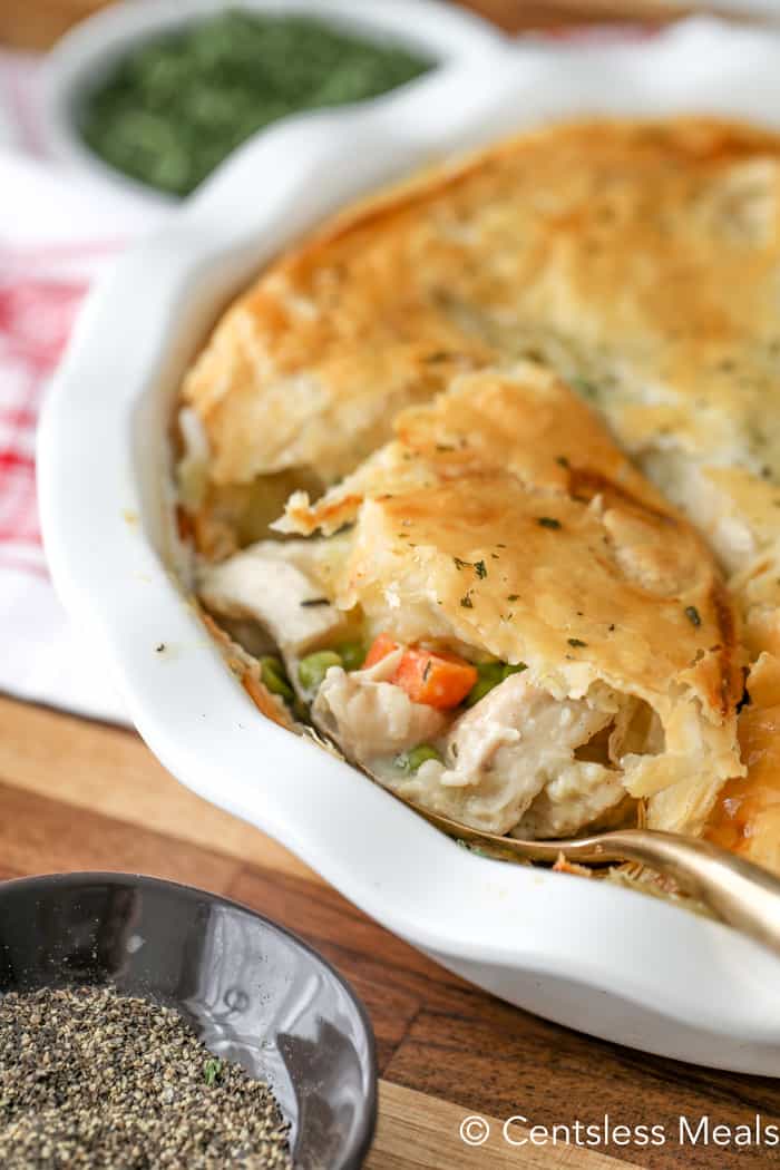 Chicken pot pie in a white pie plate with a spoon