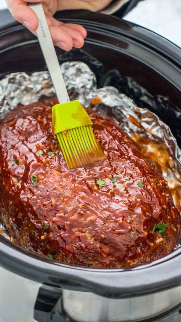 Crockpot Meatloaf being brushed with sauce
