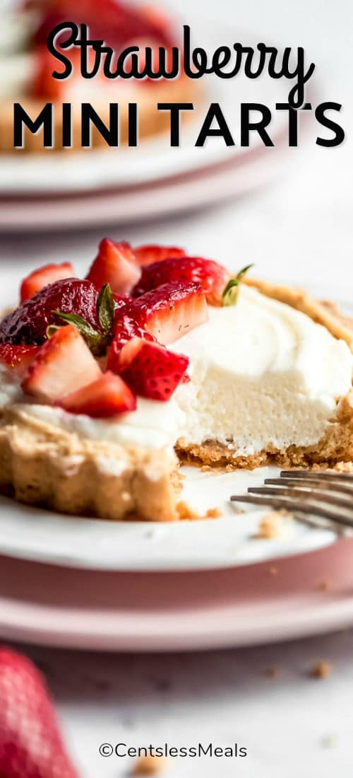 Strawberry mini tart on a plate with strawberries and a title