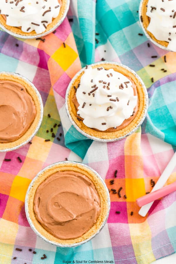 five mini chocolate cheesecakes on a colorful fabric napkin.