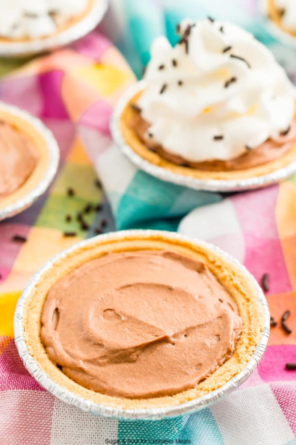 no bake chocolate cheesecake with more mini chocolate cheesecakes in the background.