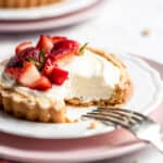 Strawberry mini tarts on plates with a fork