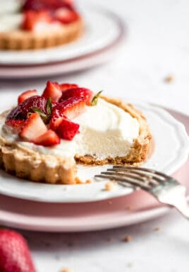 Strawberry mini tarts on plates with a fork