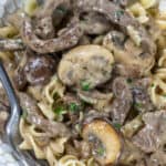 Beef stroganoff in a bowl with a fork garnished with pepper and parsley