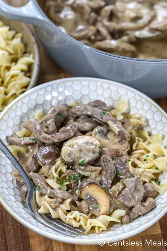 Beef stroganoff in a bowl with a fork garnished with parsley
