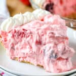 Berry fluff pie on a plate with whipped cream