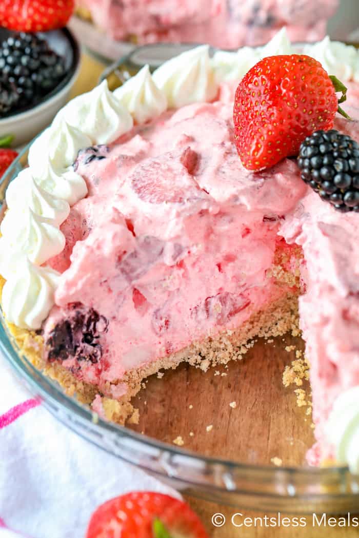Berry fluff pie in a pie plate with a piece taken out
