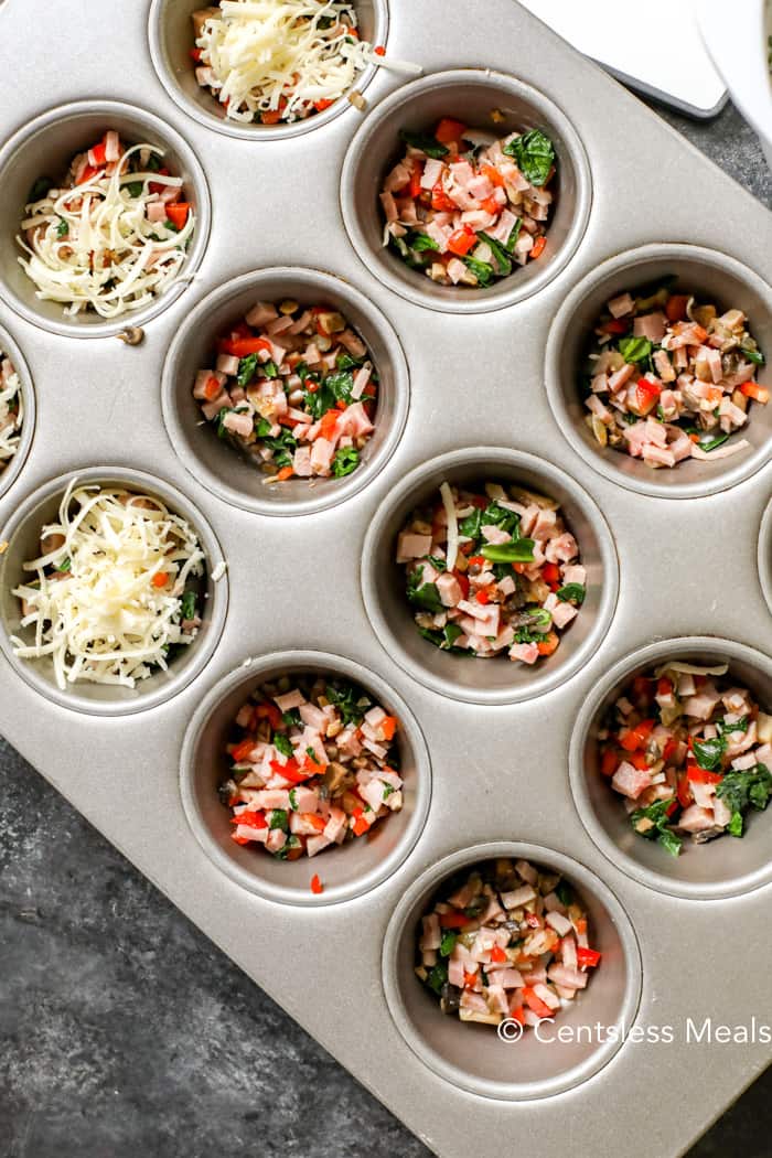 Ingredients for egg muffins in a muffin tin