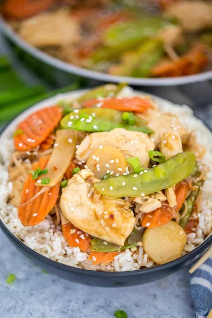 Moo Goo Gai Pan on a bed of rice garnished with sesame seeds and green onions