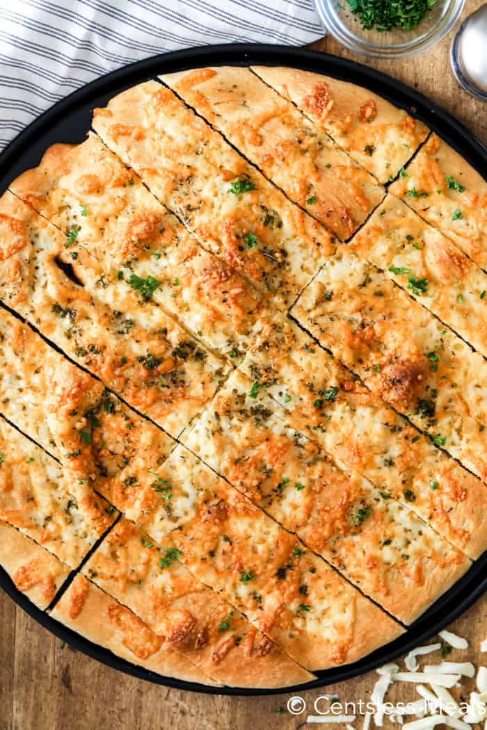 Pizza dough breadsticks on a pizza sheet with parsley