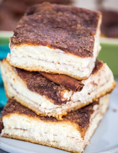 Stack of Sopapilla Cheesecake on a plate with a cinnamon stick