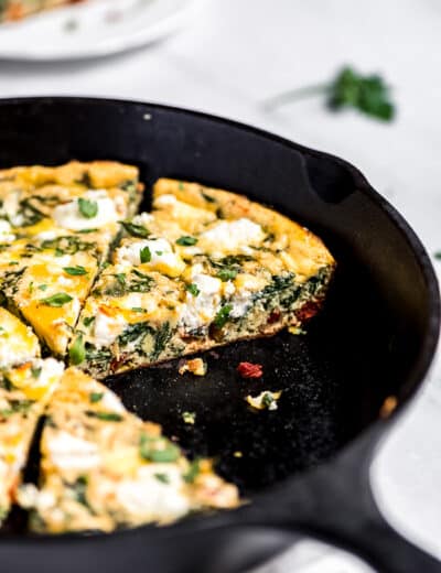 Spinach frittata in a pan with a slice taken out