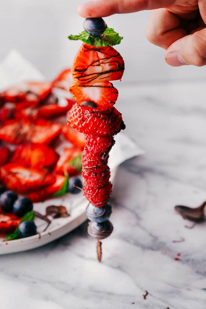 Fruit kabob standing upright drizzled with chocolate