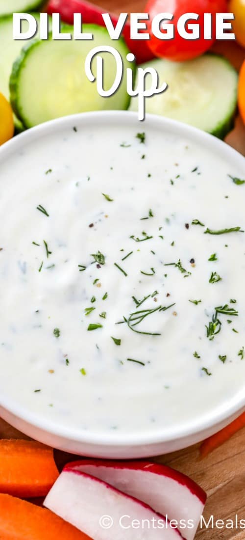 Dill veggie dip in a white bowl with veggies on the side