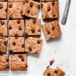 Chocolate chip cookie bars cut into squares on parchment paper
