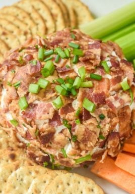 Bacon Ranch Cheeseball on a plate with crackers, celery and carrots overhead