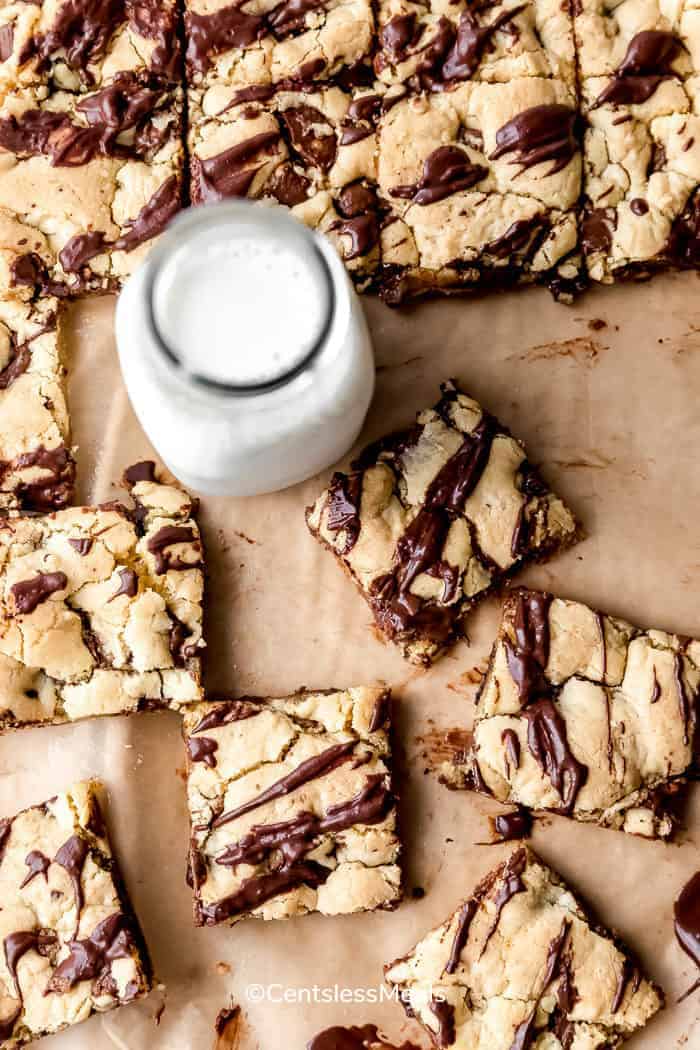 Cake mix cookie bars cut into squares with a jar of milk
