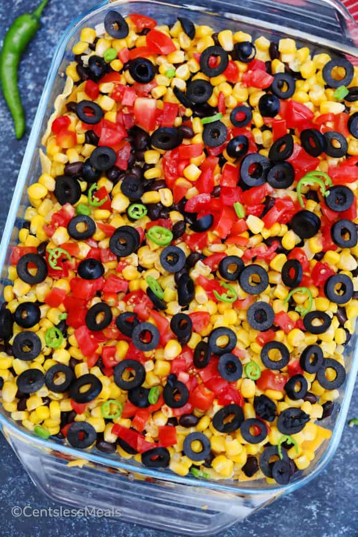 Uncooked chicken nachos in a clear casserole dish