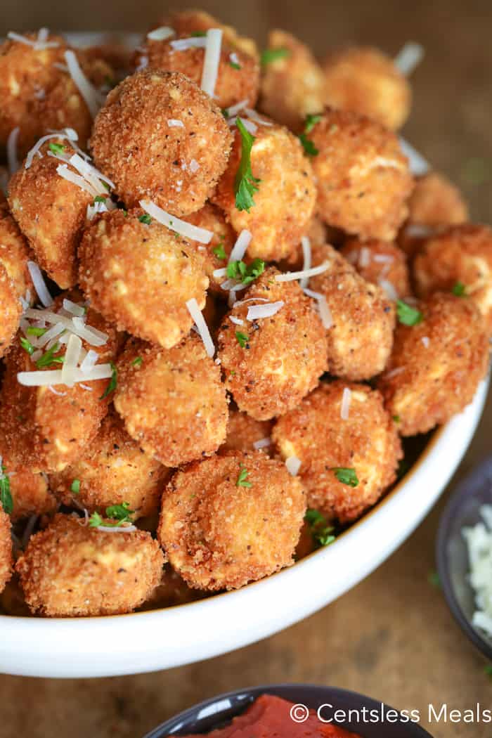 Crispy fried tortellini with parsley and shredded cheese in a bowl