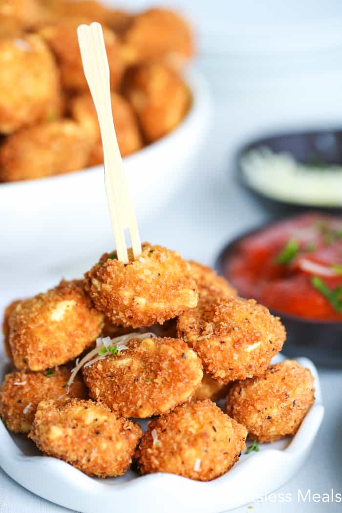 Crispy fried tortellini in a dish with a wooden Fork