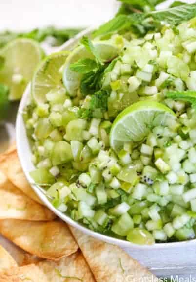 Mojito fruit salsa in a white bowl with chips on the side