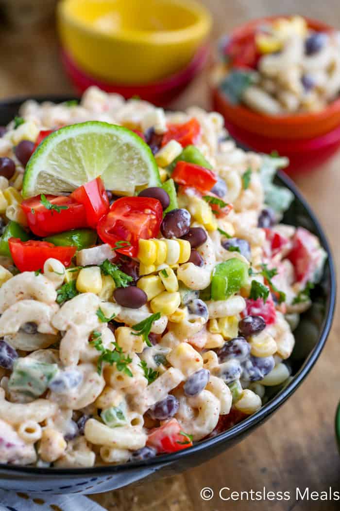 Southwestern macaroni salad in a bowl with a lime wedge and cilantro