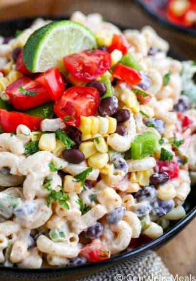 Southwestern macaroni salad in a bowl with a lime wedge on top