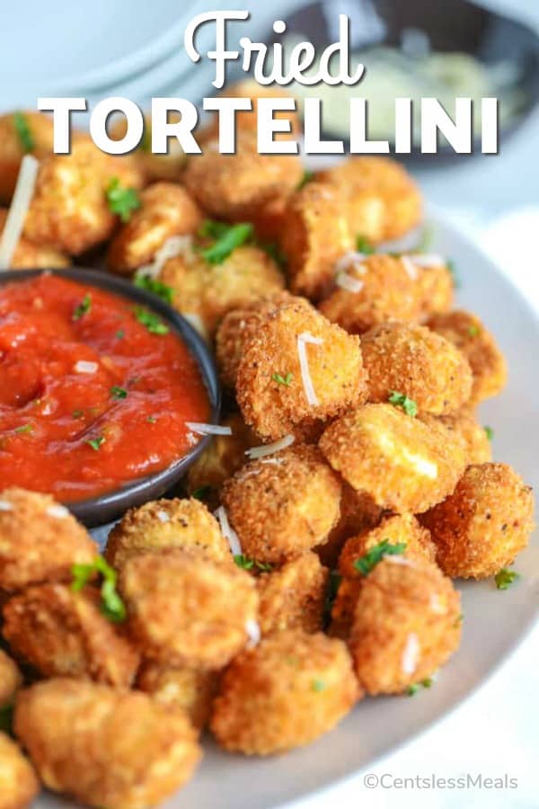 Fried tortellini on a plate with sauce and writing