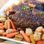 Slow cooker pot roast on a plate with veggies and parsley