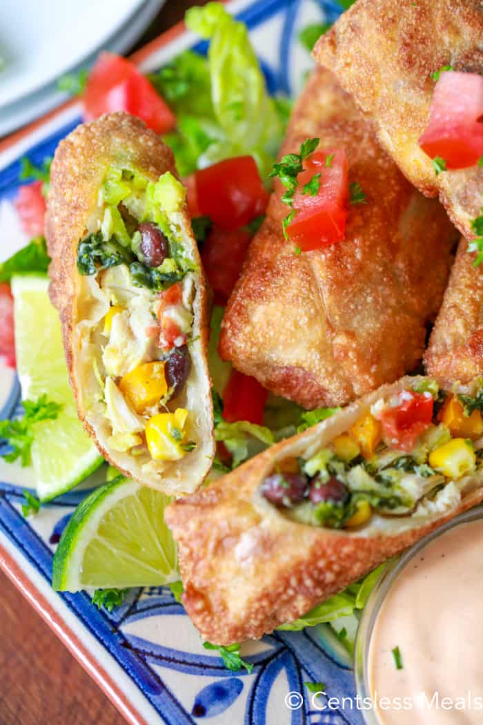 Avocado egg rolls on a plate with one cut open