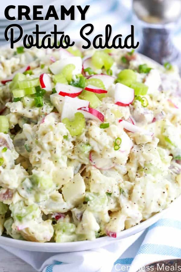 Creamy potato salad in a white bowl with writing