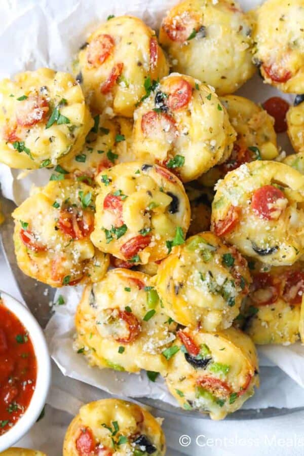 Pizza mac and cheese bites on a plate garnished with parsley