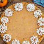 Pumpkin cheesecake with whipped cream on a wooden board