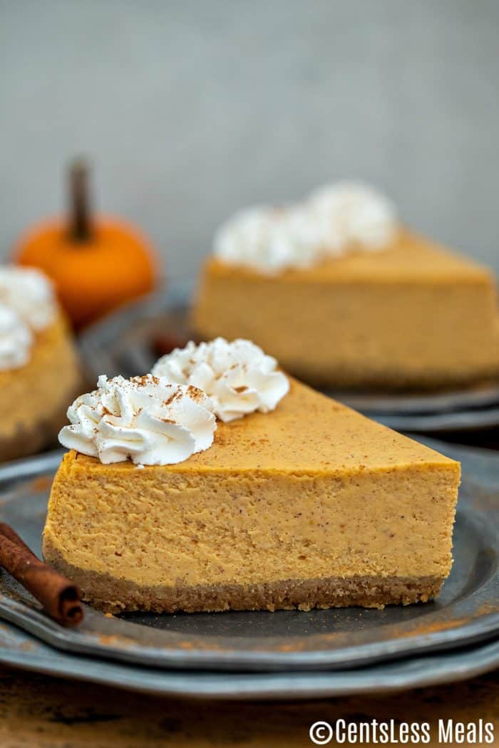 Pieces of pumpkin cheesecake on plates with whipped cream