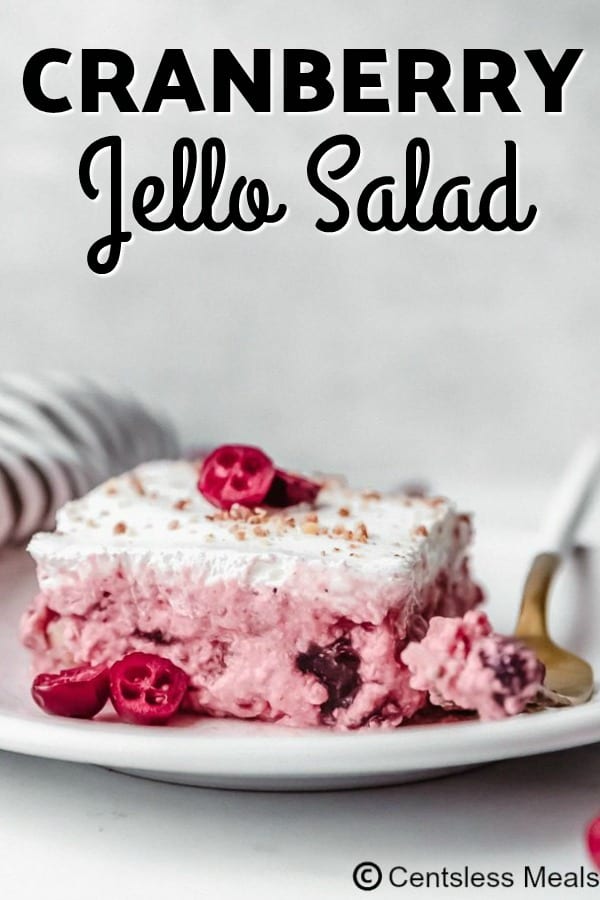 Cranberry Jell-O salad on a white plate with a fork and a title