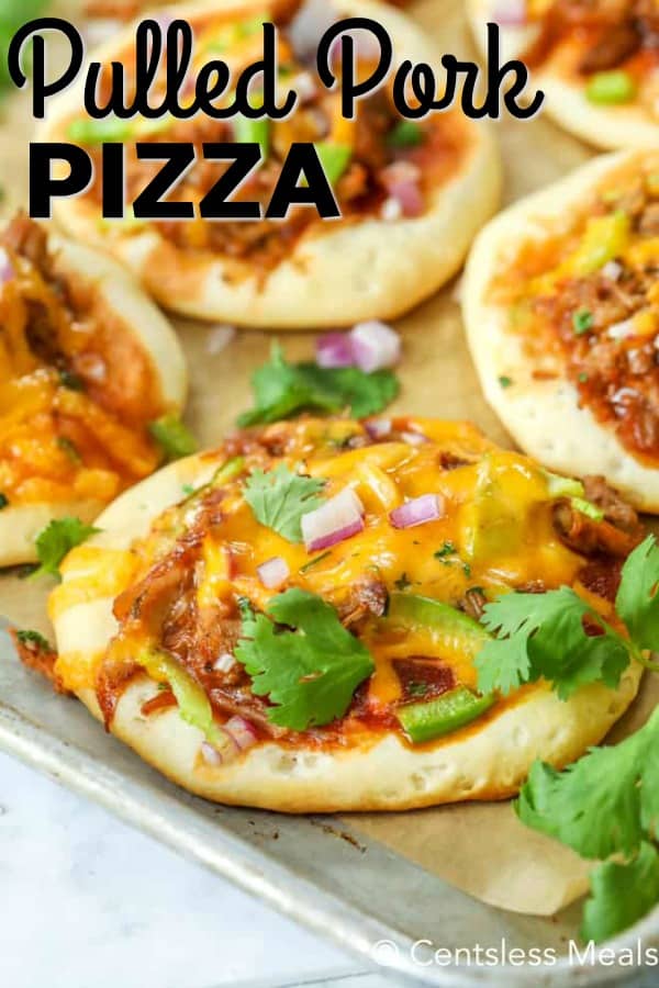 Mini pulled pork pizzas on a baking sheet with writing