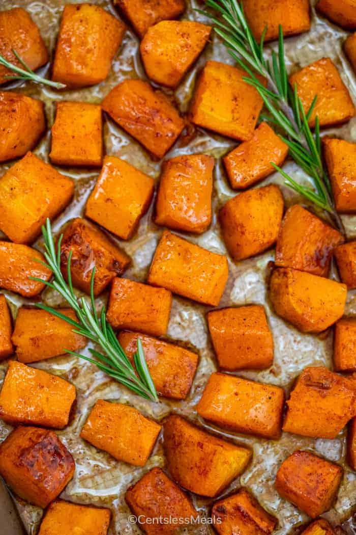 Roasted butternut squash on a baking sheet with rosemary