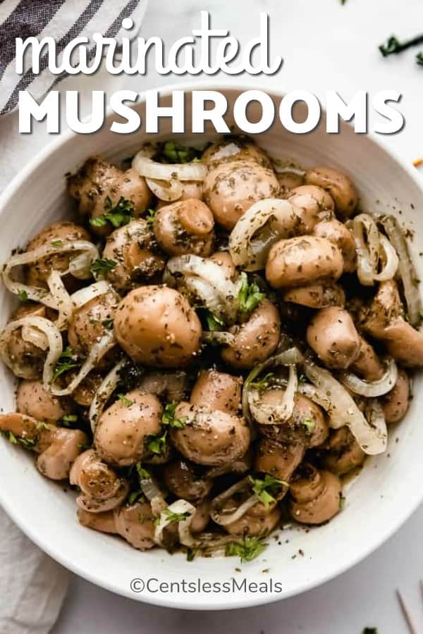 Marinated mushrooms in a bowl with onions and parsley with a title