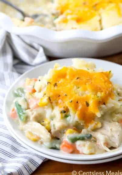Turkey pot pie on a white plate with a pie dish in the background