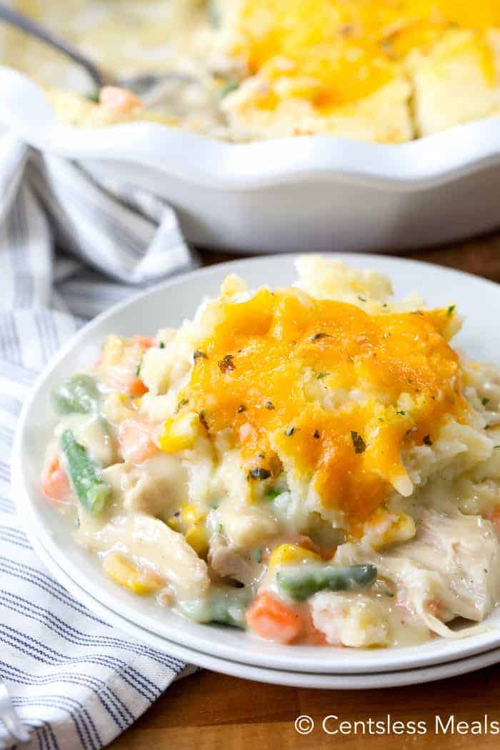 Turkey pot pie on a white plate with a pie dish in the background