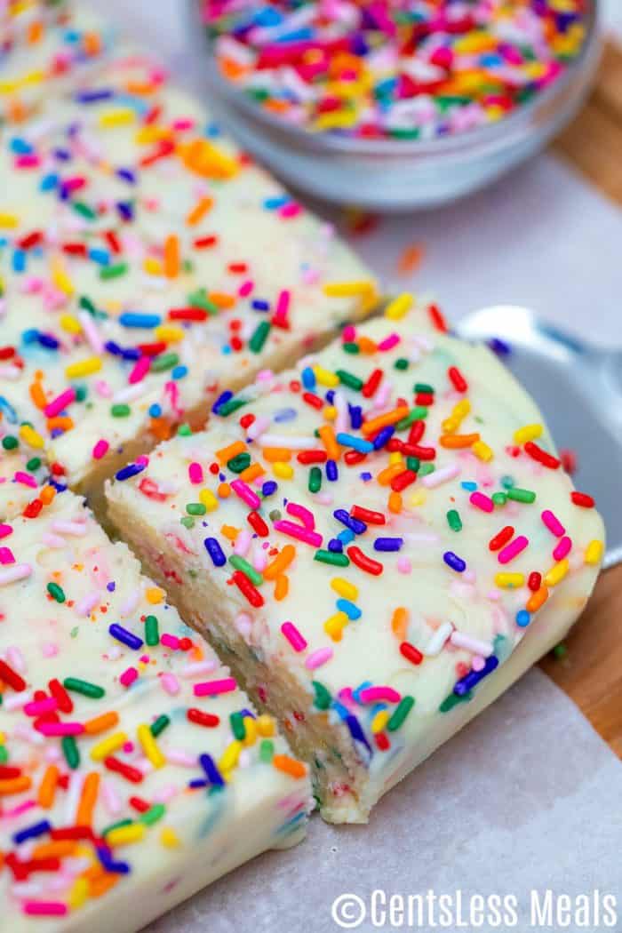 Vanilla Fudge with rainbow sprinkles and sprinkles in the background in a bowl