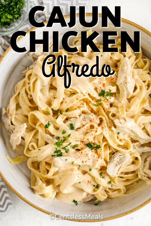 Cajun chicken alfredo in a bowl with parsley with writing