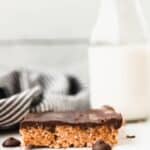 Peanut butter Rice Krispie Treat on a marble board with milk in the background