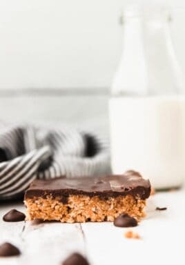 Peanut butter Rice Krispie Treat on a marble board with milk in the background