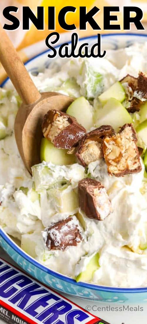 Snicker salad in a bowl with a wooden spoon and a title