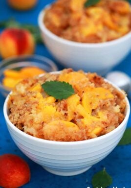 Peach Dump Cake in served in white bowls.