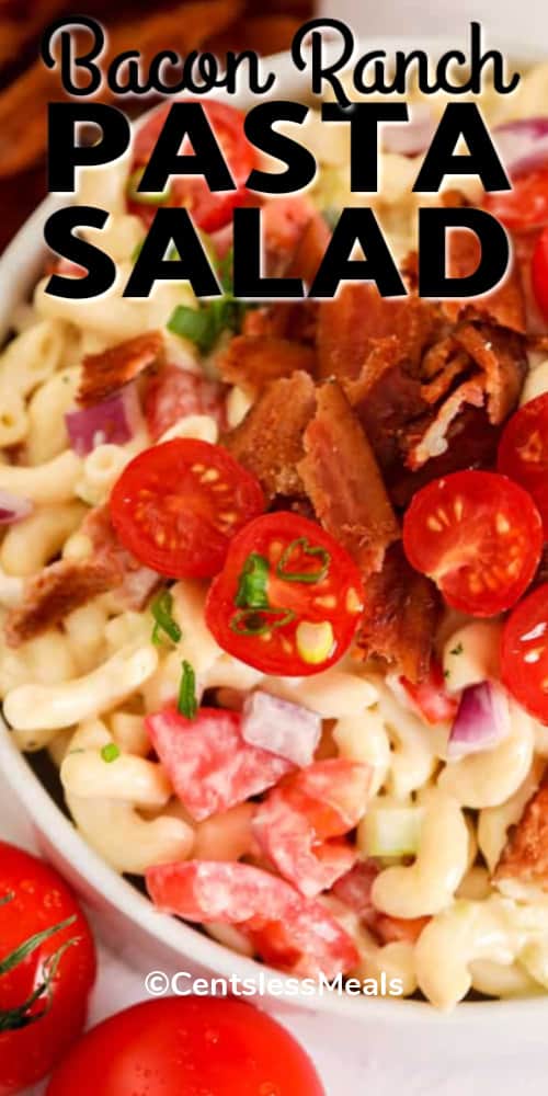 Bacon Ranch Pasta Salad in a white bowl, garnished with tomatoes, bacon and green onion, with a title.