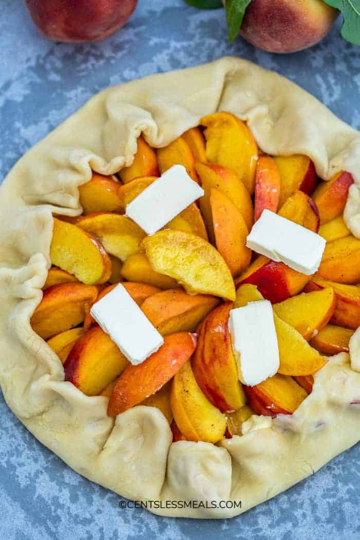 Peach Galette crust stuffed with peaches and topped with butter.