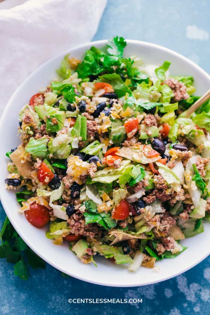 Taco Salad Bowl served in a white bowl on a blue background.