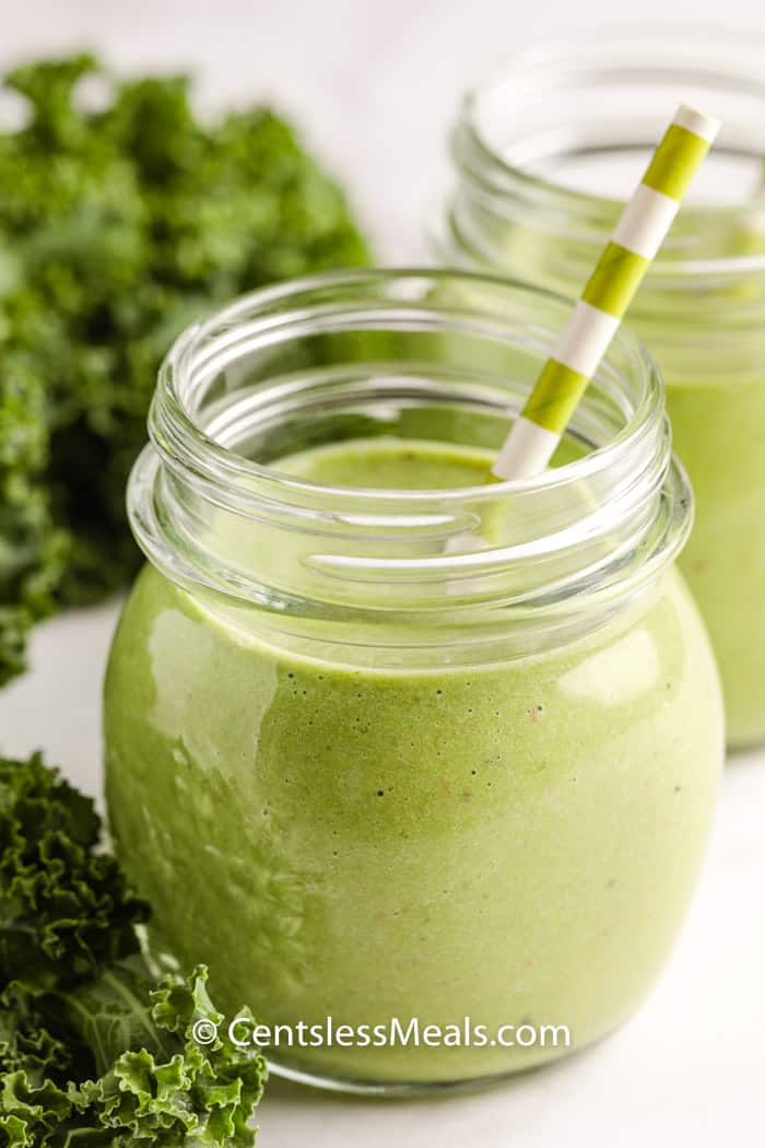 healthy Green Smoothie in glasses with a straw